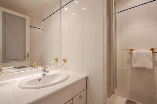 une salle de bain blanche avec un lavabo et un miroir dans l'établissement NEWLY RENOVATED! Harbour View on Balcony Terrace, à Cannes