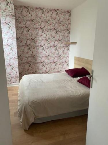 - une chambre avec un lit orné d'un mur fleuri dans l'établissement Le Brétigny Logement 6 personnes, à Joinville-le-Pont
