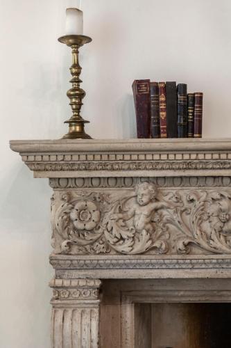 a lamp on top of a fireplace with books at Villa Tuzzo in Lecce