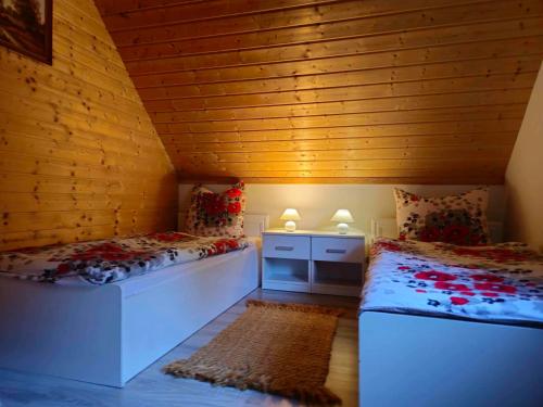 a room with two beds in a room with a wooden ceiling at Domki pod Polaną in Lesko