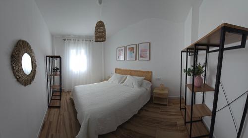 サン・ホセにあるAires del Cabo San Joséの白いベッドと鏡のある寝室