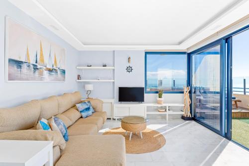 Una sala de estar con un sofá y un televisor. en La Mar Loft Apartment with Hot Tub, en Puertito de Güímar