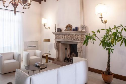 a living room with a fireplace and white furniture at Villa Tuzzo in Lecce