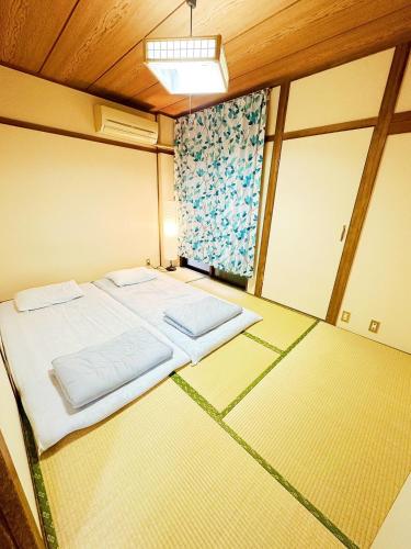 a small room with a bed and two windows at メゾンドリバージュ201 in Tokyo