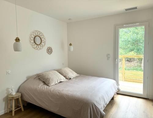 une chambre blanche avec un lit et une fenêtre dans l'établissement Charmant ensemble de 2 villas, à Léon