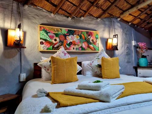 a bedroom with a bed with pillows and a painting on the wall at Winterton Country Lodge @ Rose Cottage in Winterton