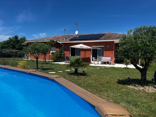 une maison avec une piscine devant une maison dans l'établissement L'Etape Landaise - Maison d'Hôtes, à Gousse