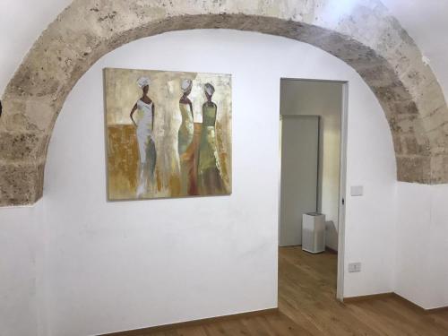 a painting of three women on a wall in a room at Suite vecchia Dante in Bari