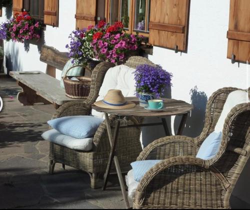 a table with wicker chairs and a table with flowers at Heissbauer in Wackersberg
