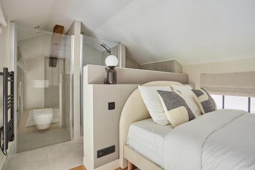 - une chambre avec un lit blanc et une douche dans l'établissement Amazing Apartment Le Marais Center of Paris by Studio Prestige, à Paris