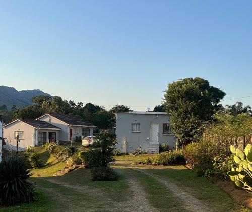 a yard with houses and a dirt road at African Violet in Mbabane