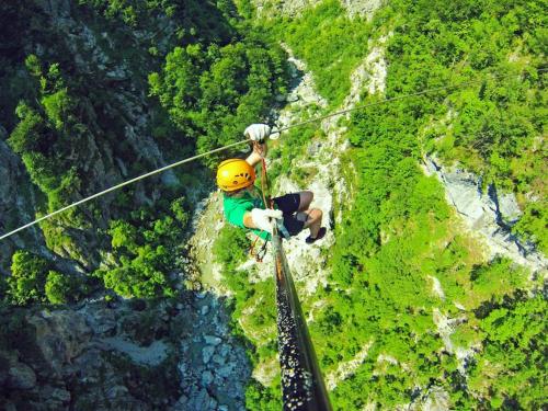 a person in a helmet on a zip line at Apartma na podeželju Marta- Slovenia Nature in Kanal