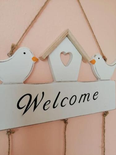 three white birds sitting on a welcome sign at Apartma na podeželju Marta- Slovenia Nature in Kanal