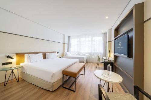 a hotel room with a large bed and a tv at Eurostars Acteón in Valencia