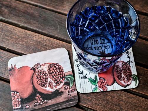 a glass vase with a picture of pomegranates and a bowl at Winterton Country Lodge @ Rose Cottage in Winterton