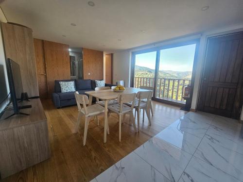 a living room with a table and chairs and a couch at Quinta da Valdigueira in Armamar