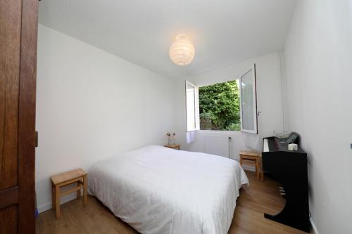 une chambre avec un lit blanc et une fenêtre dans l'établissement Maison les Lilas, à Gérardmer