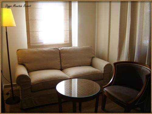 a living room with a couch and a table at Styga Mountain Resort in Zarouchla