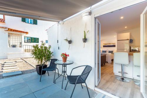 a patio with a table and chairs and a kitchen at Moro's Friends House - Cascais in Cascais