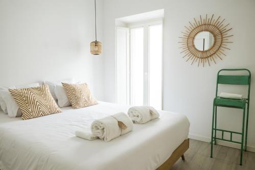 a bedroom with a white bed with towels on it at Clover House Tavira in Tavira