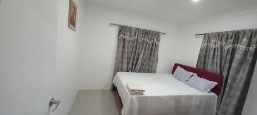 a small bed in a room with curtains at Gounders Apartmemt in Singatoka