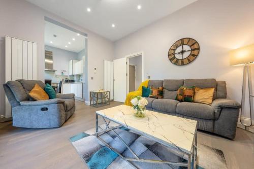 a living room with a couch and a table at Maida Vale - Carlton Vale Apartments in London