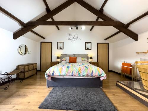 LlandysulにあるThe Stablesの木製の天井の部屋にあるベッドのある寝室