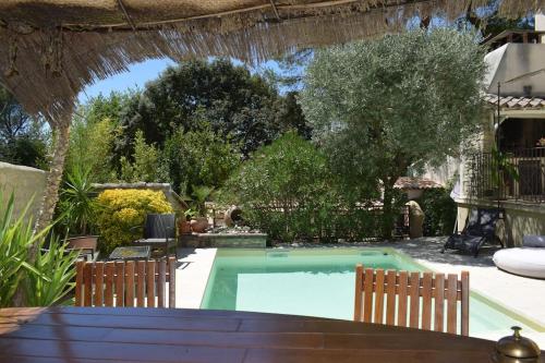 - une piscine dans une cour avec 2 chaises dans l'établissement Maison provençale de charme, à Pernes-les-Fontaines