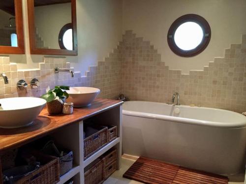 une salle de bain avec deux lavabos et une baignoire dans l'établissement Maison provençale de charme, à Pernes-les-Fontaines