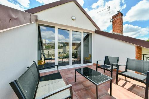 a patio with chairs and a glass table at Enjoy Garden in Vierzon