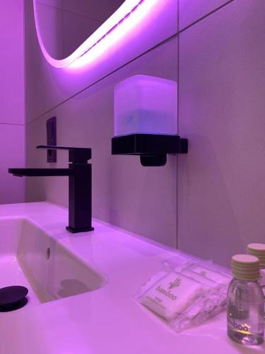 a bathroom with a sink and a purple light at Pension FeWo Schwärzer in Weiherhammer