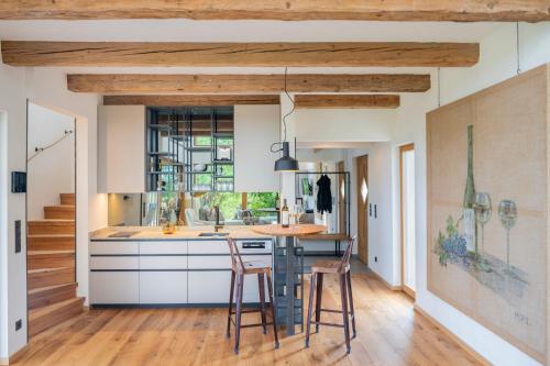 a kitchen with wooden ceilings and a counter with stools at steiRerBLiCke - Winzerhäuser an der südsteirischen Weinstraße in Glanz an der Weinstraße 