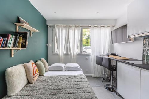 Pokój z kanapą, biurkiem i oknem w obiekcie GuestReady - Mini studio tout équipé aux Chartrons w mieście Bordeaux