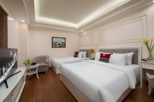 a hotel room with two beds and a flat screen tv at Sapa Praha Hotel in Sa Pa
