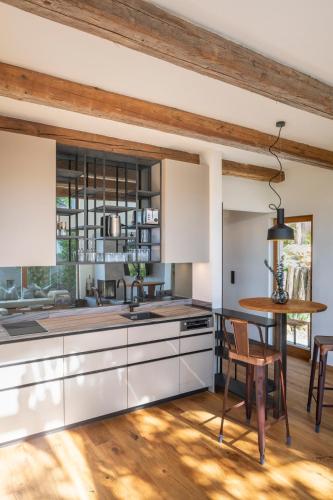 a kitchen with white cabinets and a table and chairs at steiRerBLiCke - Winzerhäuser an der südsteirischen Weinstraße in Glanz an der Weinstraße 