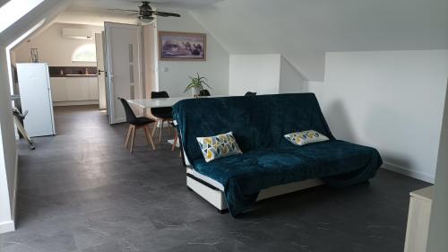 un salon avec un canapé bleu et une table dans l'établissement Appartement 8 pers neuf 80m2, à Solesmes