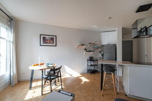 une cuisine et un salon avec une table et des chaises dans l'établissement GuestReady - T1 BIS - Cosy and Lovely, à Lyon