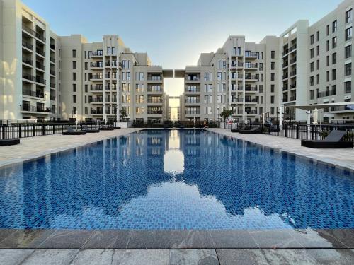 a large swimming pool in front of some apartment buildings at GuestReady - The Wandering Oasis in Town Square in Dubai