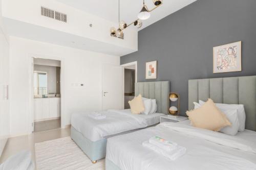 a bedroom with two beds and a bathroom at GuestReady - The Wandering Oasis in Town Square in Dubai