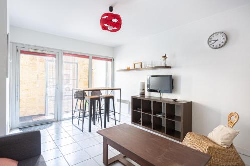 a living room with a table and a tv at GuestReady - Appartement Cours du Médoc in Bordeaux