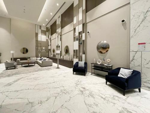 a lobby with couches and chairs and a large marble floor at GuestReady - Sweet Escape in Dubai
