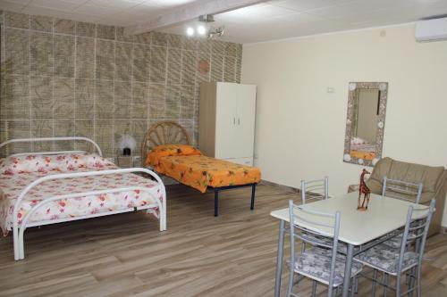 a bedroom with a bed and a table and a table and chairs at Casa vacanze da Cosimo BEIGE in Porto Cesareo