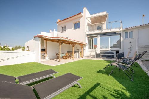 a backyard with lawn chairs and a house at GuestReady - Amor & Mar in Caparica