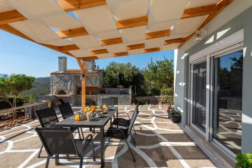 a patio with a table and chairs under a pergola at Nikolas Memories in Agios Nikolaos
