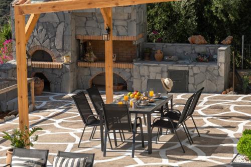 a patio with a table and chairs in front of a stone oven at Nikolas Memories in Agios Nikolaos
