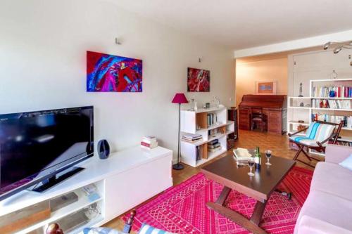 un salon avec une grande télévision à écran plat dans l'établissement GuestReady-Spacious apartment near Exhibition Park, à Paris