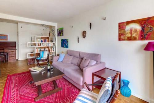 un salon avec un canapé rose et une table dans l'établissement GuestReady-Spacious apartment near Exhibition Park, à Paris