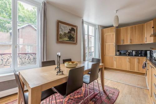 - une cuisine avec une table et des chaises en bois dans la chambre dans l'établissement GuestReady - Bel Apt pour 4 / Luxembourg -Assas, à Paris