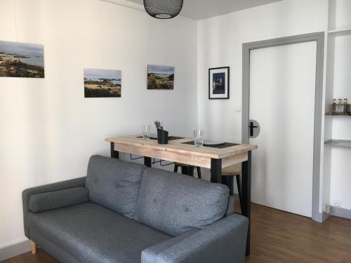 un salon avec un canapé et une table en bois dans l'établissement Studio Le Saint Paul, Granville, à Granville