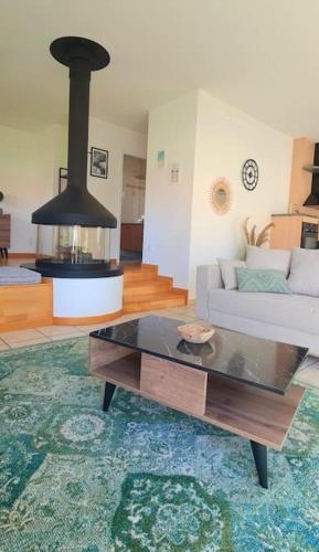 a living room with a couch and a stove at Maison d'architecte in Cébazat